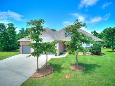 View of front of house featuring concrete driveway, brick siding, a front yard, and an attached garage