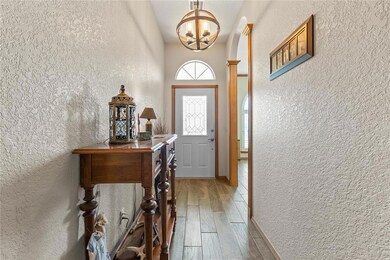 Doorway featuring a chandelier and wood-type floor