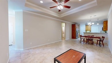 Living room with a tray ceiling, crown molding, ba