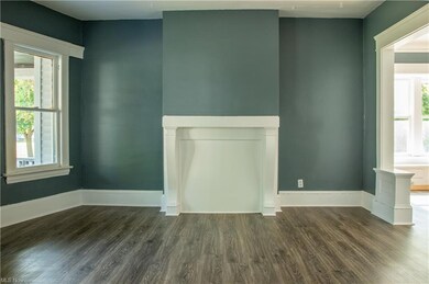 Unfurnished living room with dark hardwood floors
