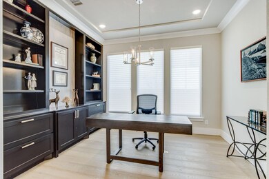 The study is an open concept with custom shelving & drawers accents to match the rotunda.  This room is a flexible space that could accommodate a formal dining space.