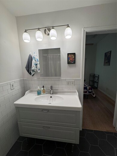 Full bath with tile walls, wainscoting, tile patt
