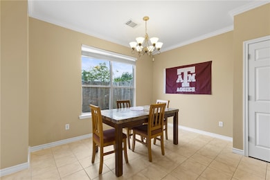 Dining room with ornamental molding, light tile patterned flooring, and a chandelier