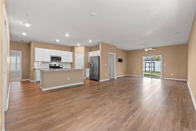 Kitchen featuring a kitchen island with sink, open
