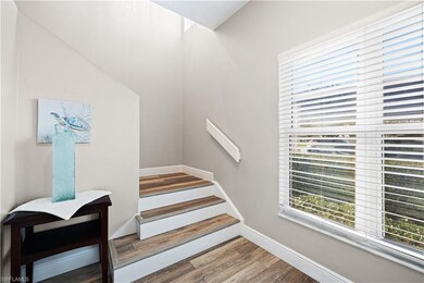 Staircase with plenty of natural light and wood finished floors