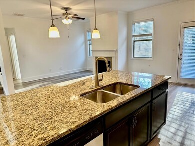 Kitchen featuring crown molding, light wood-style flooring, healthy amount of natural light, and light stone countertops