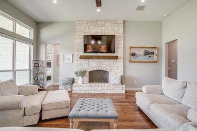 Living room with a fireplace, visible vents, wood 