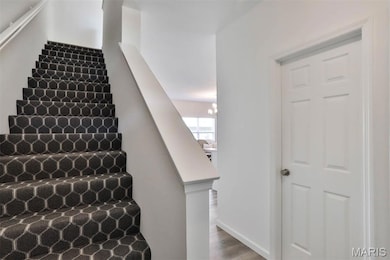 Stairs featuring a chandelier and wood finished floors
