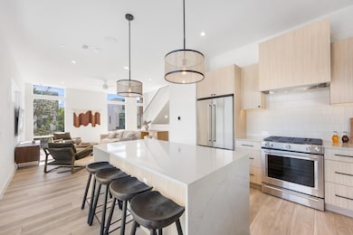 Kitchen with stainless steel appliances, light br