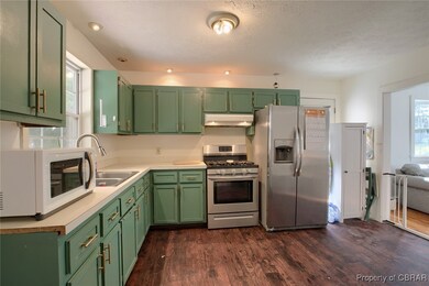 Kitchen featuring dark wood-type flooring, applian
