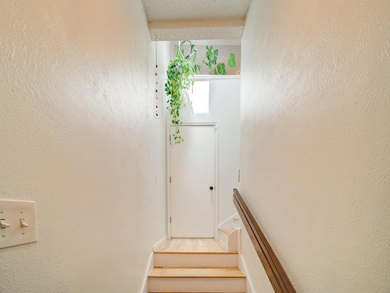 Stairway featuring a textured ceiling