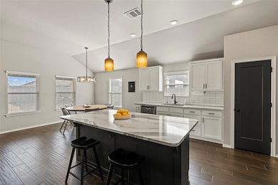 Kitchen with a sink, visible vents, vaulted ceilin