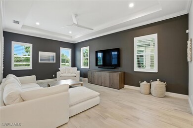 Living room featuring a tray ceiling, crown moldin