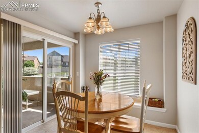 Dining space with light colored carpet and a chandelier