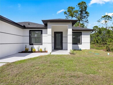 View of front of property with a front yard, stucco siding, and roof with shingles