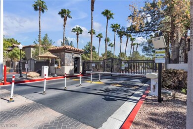 View of asphalt road featuring a gate, curbs, and