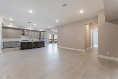 Kitchen featuring gray cabinets, wall chimney rang