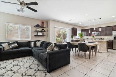 Living room featuring a ceiling fan, light tile pa