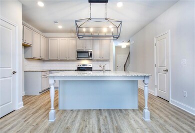 Kitchen featuring an island with sink, stainless s