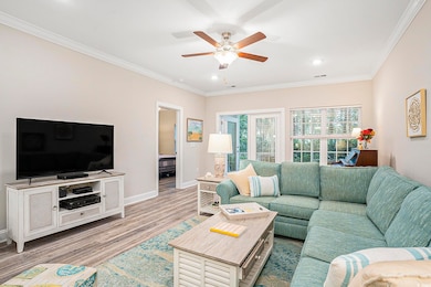 Living area featuring ornamental molding, light wood-style flooring, a ceiling fan, and recessed lighting