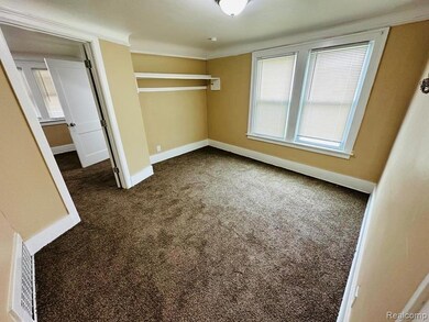 Unfurnished bedroom featuring carpet floors, multiple windows, and ornamental molding