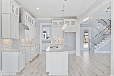 Kitchen featuring a sink, wall chimney range hood,