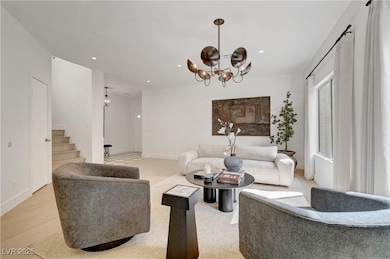 Living room featuring a chandelier, stairway, rece
