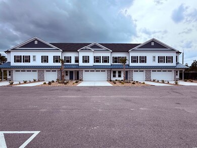View of property featuring driveway, metal roof, a