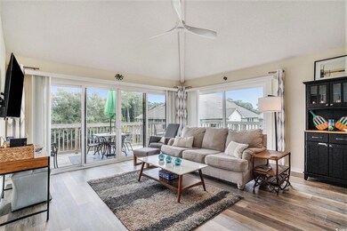 Living area featuring light wood-type flooring, vaulted ceiling, and ceiling fan