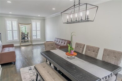 Dining room with crown molding, wood finished floors, recessed lighting, and a chandelier