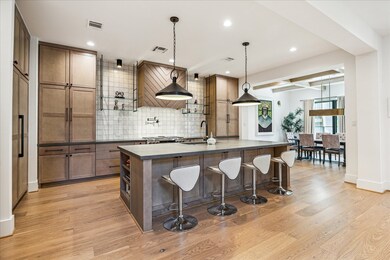 Kitchen has sleek white tile backsplashes, built-i