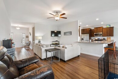 Living room featuring ceiling fan and dark hardwoo