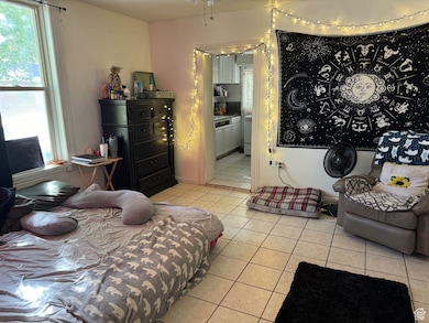 Bedroom with ensuite bath and light tile patterned floors