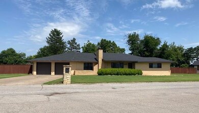 Ranch-style home with driveway, an attached garage, and a chimney