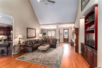 Living room open to the dining room and foyer with a built-in cabinet.