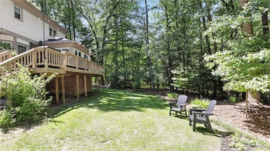 View of green lawn featuring a wooden deck and vie