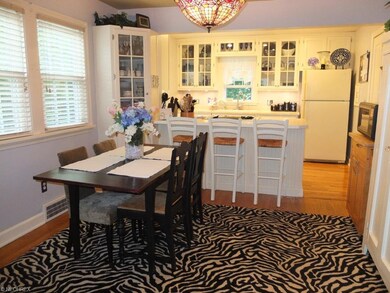 Dinette with hardwood floors is open to the kitche
