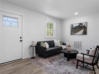 Living room featuring visible vents, baseboards, r