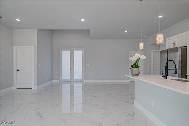 Kitchen with light marble finish flooring, hanging