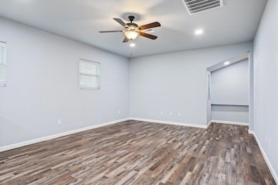 Unfurnished room featuring a ceiling fan and wood