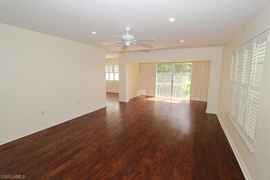 Spare room with a healthy amount of sunlight, dark hardwood / wood-style floors, and ceiling fan