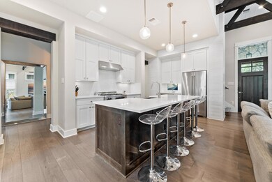 Kitchen featuring under cabinet range hood, light