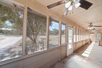 Unfurnished sunroom featuring a ceiling fan and h