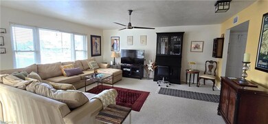 Carpeted living room featuring ceiling fan