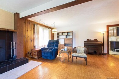 Large living room with exposed beams and hardwood 
