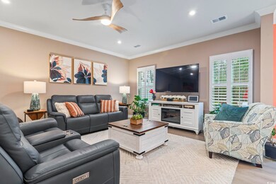 Living room featuring crown molding, plenty of nat
