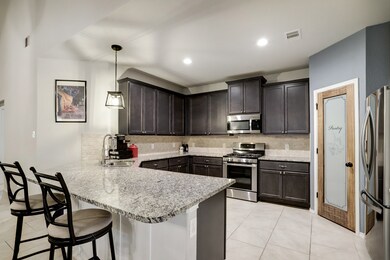 The kitchen is outfitted with a stainless steel appliance package and features a breakfast bar  open to the living area.