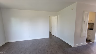 Spare room featuring dark wood-type flooring, base