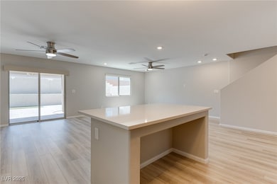 Kitchen with ceiling fan, baseboards, a center isl