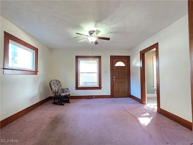 Carpeted foyer entrance featuring plenty of natural light and a ceiling fan